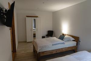 sypialnia z 2 łóżkami i telewizorem w obiekcie Zimmerfrei-Barz w mieście Ahlefeld