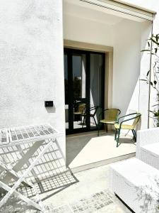 Una vista de un patio con sillas y una mesa. en Perla dello Ionio luxury apartments, en Torre Lapillo 3 fotos más
