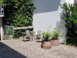 a patio with a table and chairs and plants at Apartment central in Bad Saulgau
