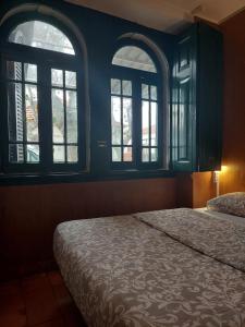 a bedroom with two windows and a bed in it at Beach House São Pedro in São Pedro do Estoril
