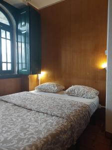 a bedroom with a bed with two pillows and a window at Beach House São Pedro in São Pedro do Estoril +49 photos
