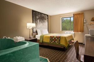 a hotel room with a bed and a bath tub at Super 8 by Wyndham Mayfield in Mayfield