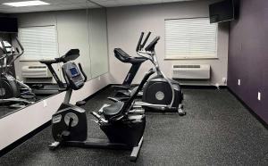 a gym with three exercise bikes in a room at Baymont by Wyndham College Station in College Station