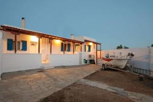 una casa con un barco estacionado frente a ella en "Triacanthos" 3 bedroom house, en Moutsoúna