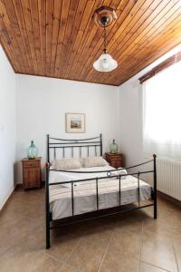 um quarto com uma cama e um tecto em madeira em "Triacanthos" 3 bedroom house em Moutsoúna