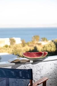 a slice of watermelon sitting on a table with books at "Triacanthos" 3 bedroom house in Moutsoúna