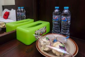 uma mesa com duas garrafas de água e um prato de comida em RedDoorz at Hotel Rich Parepare near Pantai Mattirotasi em Parepare