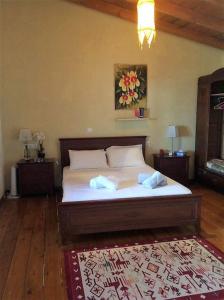 a bedroom with a bed with white sheets and a rug at Casa Benavista in Kerásia