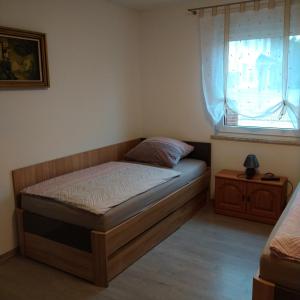a small bedroom with a bed and a window at Dori's Fewo in Mittenwalde