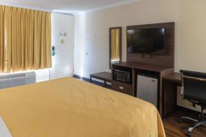 a hotel room with a bed and a flat screen tv at Quality Inn Richmond Hill - Savannah I-95 in Richmond Hill