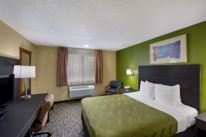 a hotel room with a large bed and a television at Quality Inn SeaTac Airport-Seattle in SeaTac
