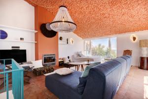 een woonkamer met een blauwe bank en een tv bij Bahia Dorada by the sea in Estepona