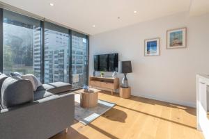 a living room with a couch and a tv at South Melbourne Short Stay Luxury & Location 01728 in Melbourne