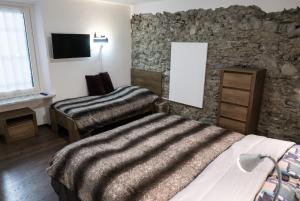 a bedroom with two beds and a stone wall at Casa Nenette VDA-AOSTA- n0108 in Aosta