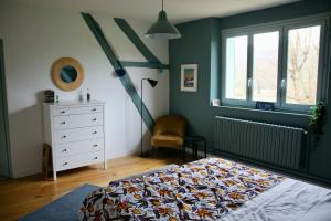 una camera con letto, cassettiera e finestre di Maison de campagne bourguignonne 19ème entièrement rénovée a Chaumot
