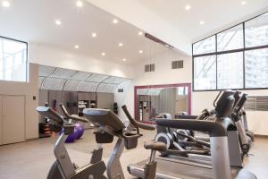 a gym with many cardio machines in a room at Hotel Plaza Santiago in Santiago