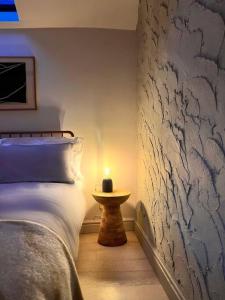 a bedroom with a bed with a candle on a table at The Bothy - A secluded and romantic rural retreat in Llanddyfnan