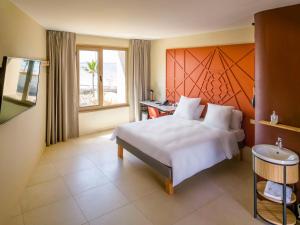 a bedroom with a large white bed and a window at Ibis Styles Mayotte Aéroport in Pamandzi