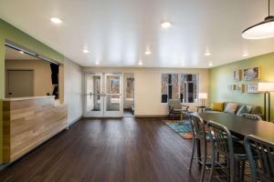 a living room with a table and chairs at WoodSpring Suites Grand Rapids Kentwood in Grand Rapids