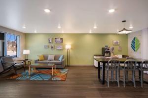 WoodSpring Suites Grand Rapids Kentwood في غراند رابيدز: غرفة معيشة مع أريكة وطاولة