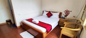 a small bedroom with a bed and a chair at Thanh Hương 99 Hotel - Nội Bài in Hanoi