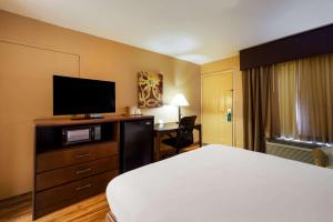 a hotel room with a bed and a flat screen tv at Quality Inn & Suites in West Helena