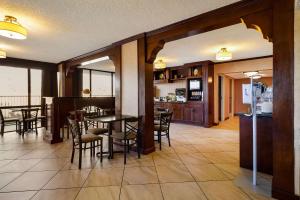 a dining room and kitchen with tables and chairs at Quality Inn & Suites in West Helena