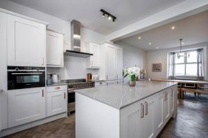 a kitchen with white cabinets and a counter top at Luxurious Manor House with Sea Views - Sleeps 10 in Amlwch