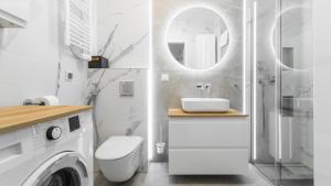 a white bathroom with a sink and a toilet at Bursztynowe Osiedle Jantar, Sun & Snow in Jantar