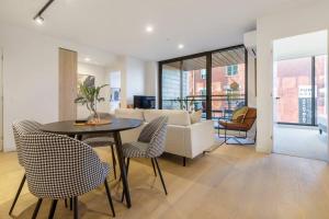 een woonkamer met een tafel en stoelen en een bank bij Nice 2-bed rental unit with free parking in Melbourne