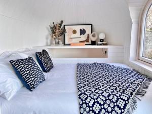 uma cama branca com almofadas num quarto em Y Caban - A Luxury Rural Retreat with Seaviews em Amlwch