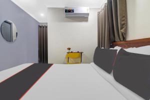 een kleine slaapkamer met een bed en een televisie bij Super Collection O Hotel Sahasra NearKondapur in Hyderabad