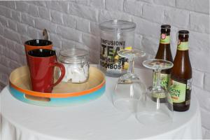 een tafel met flessen bier en glazen erop bij Les Greniers de Madelgaire in Soignies