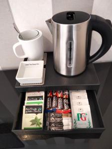 a shelf with a coffee pot and books and a cup at The Overlook Bed and Breakfast in Glastonbury