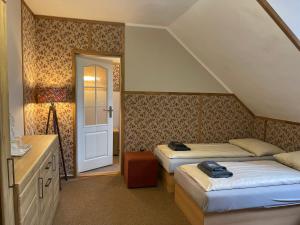 a bedroom with two beds and a sink and a door at Hotel Veveří in Veverská Bítýška