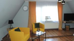 salon z 2 żółtymi krzesłami i oknem w obiekcie Zielone Tarasy na Kaszubach w mieście Sikorzyno
