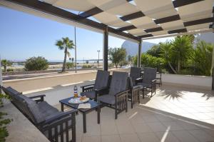 a patio with chairs and a table with a view of the beach at Villa Faro B&B in San Vito lo Capo