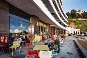 a restaurant with tables and chairs in front of a building at Sandybanks Torquay - Seaview and Promenade Apartments in Torquay +25 photos