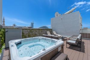 a hot tub on a patio with chairs and avisor at Beach Walk Boutique Jumeirah in Dubai