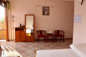 a room with two chairs and a table and a mirror at Viet Duc Guest House in Sa Pa