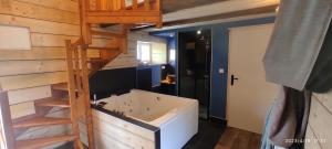 ein Badezimmer mit einer Badewanne und einer Holztreppe in der Unterkunft Ty Madelez, Chambres de charme, Gîtes, Crêperie et Spa in La Roche-Derrien