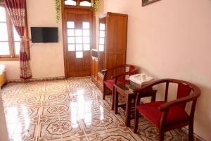 Pokój z 2 krzesłami, stołem i drzwiami w obiekcie Viet Duc Guest House w mieście Sa Pa