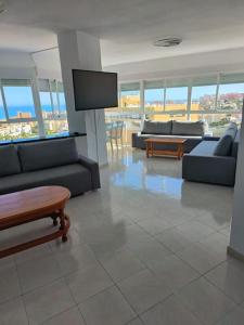 a living room with couches and a flat screen tv at Appartement Vue mer PLAYA MAR in Torremolinos
