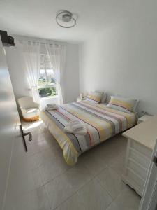a white bedroom with a bed and a window at Appartement Vue mer PLAYA MAR in Torremolinos