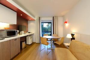a kitchen and living room with a couch and a table at Résidence Residéal Premium Cannes in Cannes
