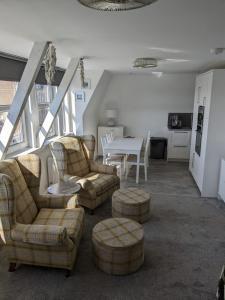 uma sala de estar com sofás e cadeiras e uma mesa em Wee Cumbrae View em Millport