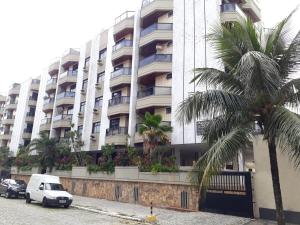 una furgoneta blanca estacionada frente a un gran edificio en Conforto a 300m da Praia do Forte, en Cabo Frío