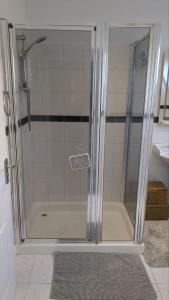a shower with a glass door in a bathroom at Wee Cumbrae View in Millport