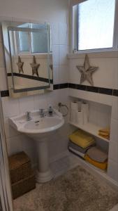 a bathroom with a sink and a mirror at Wee Cumbrae View in Millport