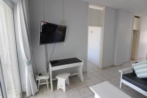 uma sala de estar com uma secretária e uma televisão na parede em Seagull 507 em Margate